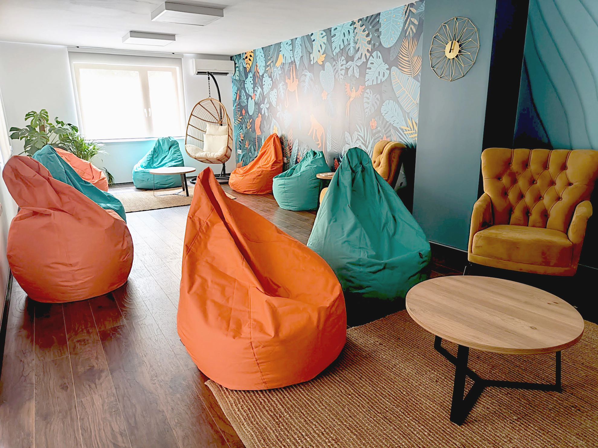 Pleasant meeting space with colorful wallpaper, beenbags and armchairs.